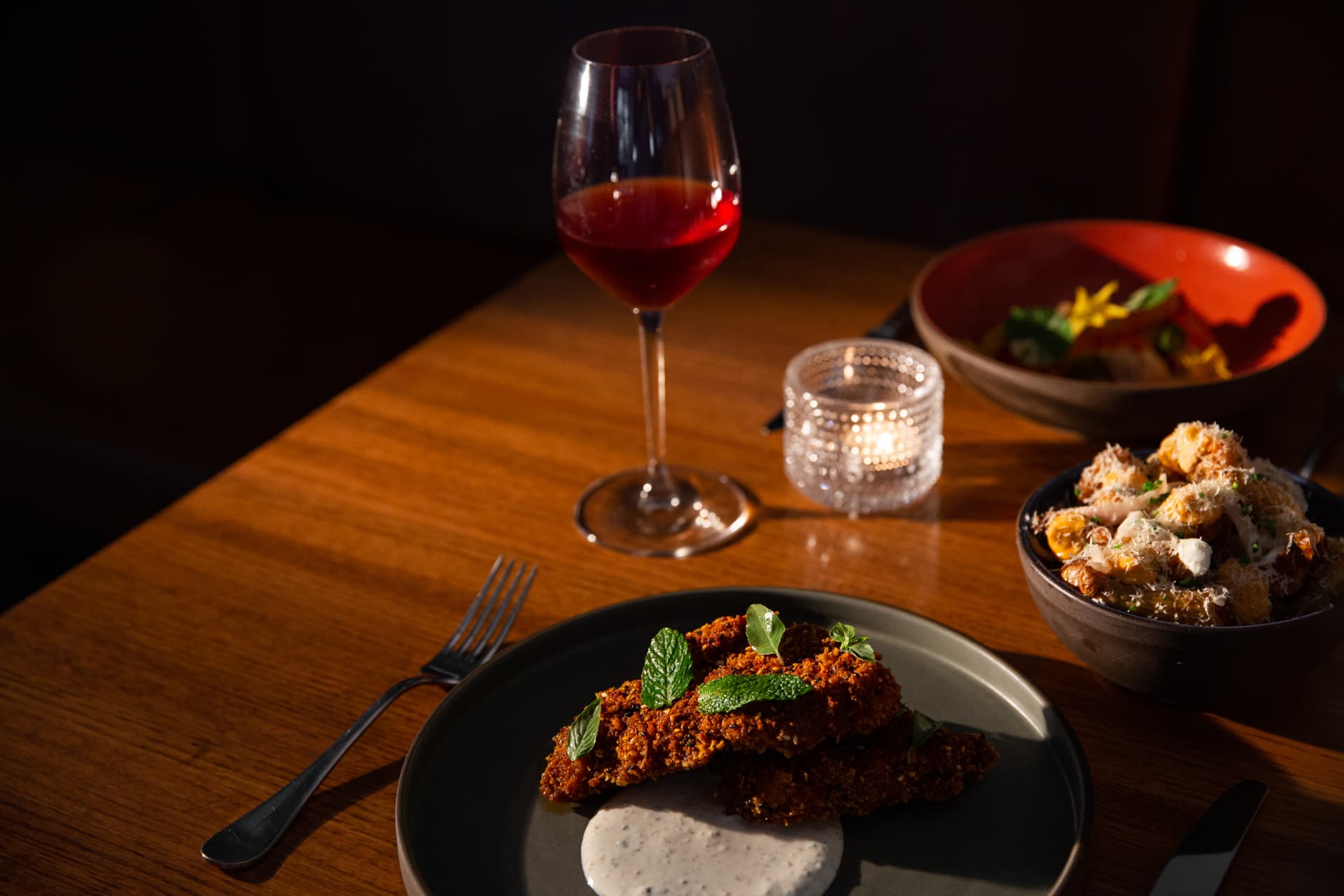 Fried green tomatoes with herbs, a glass of red and candlelight