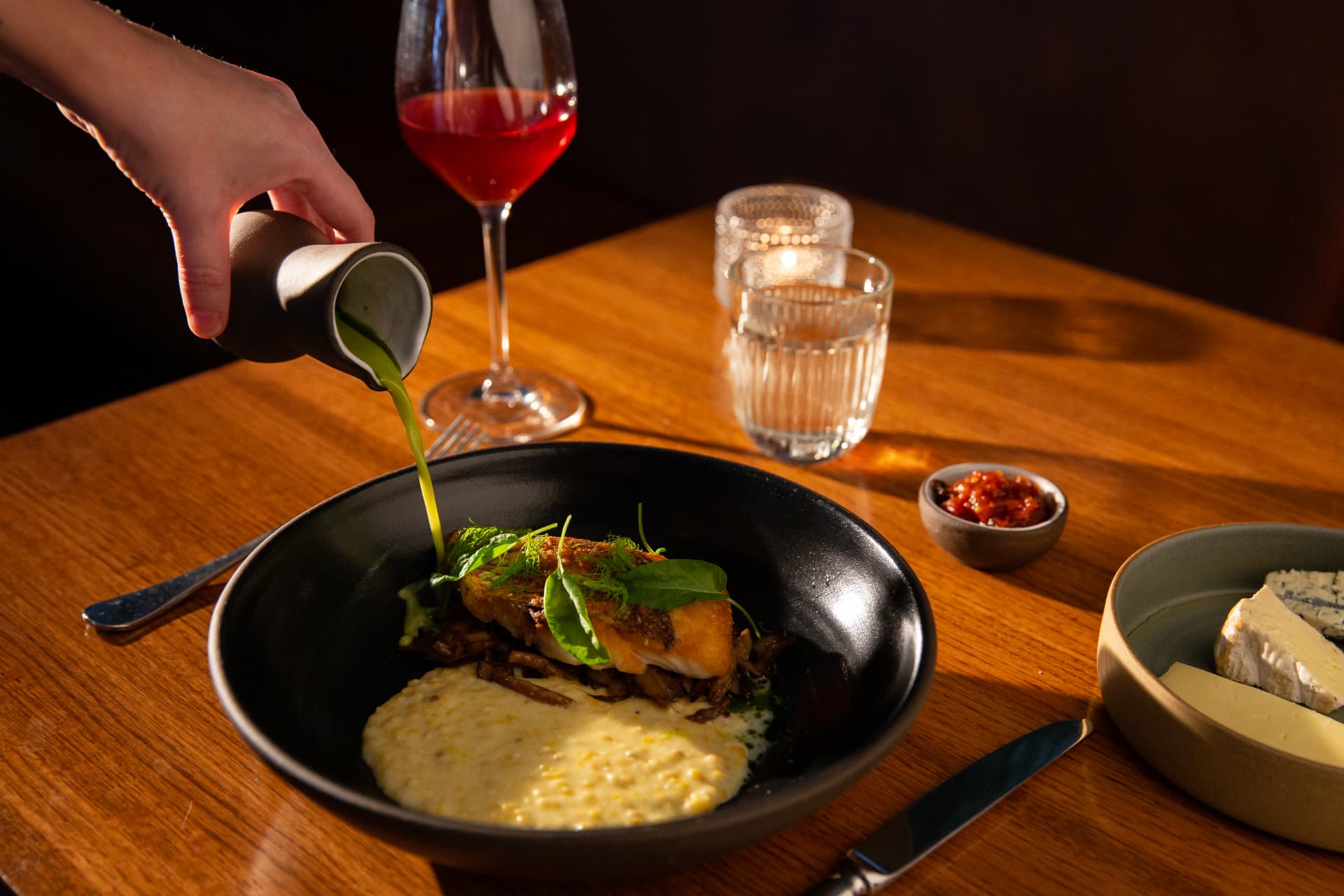 Herb oil poured over fish and creamed corn