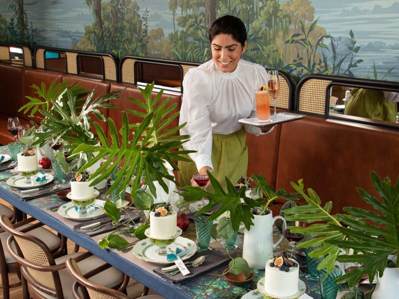 Server setting a garden-themed banquet table