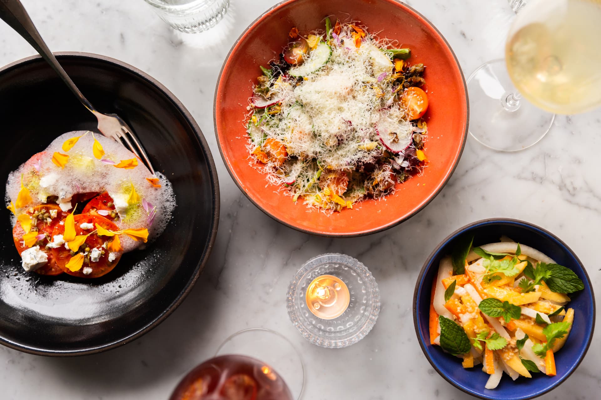 Heirloom tomato, shaved salad, and mango slaw on a marble table at St. Neo's
