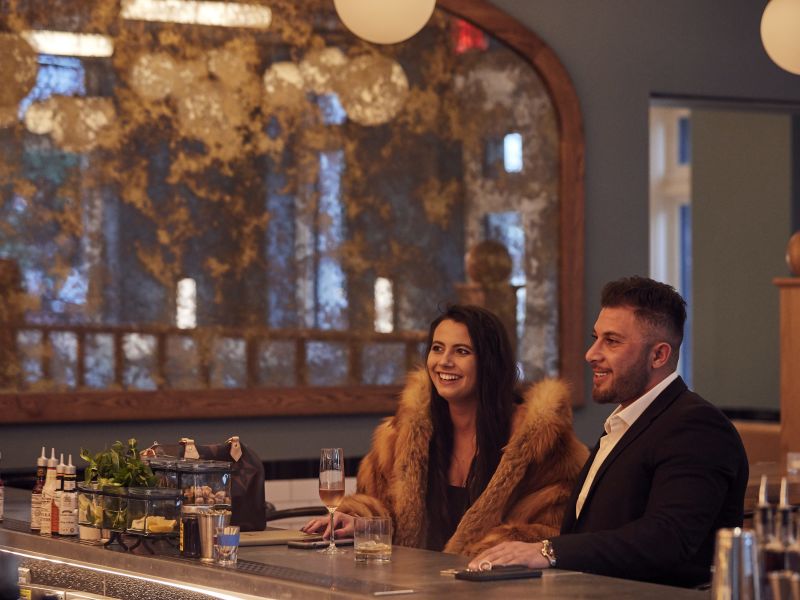 Guests enjoying drinks at the bar of St. Neo's Brasserie