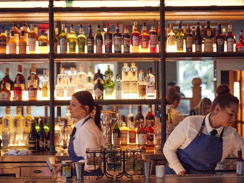 Bartenders behind the backlit bar